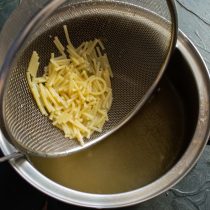 Выливаем процеженный бульон в кастрюлю, добавляем отваренную вермишель