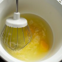 Готовим тесто. Разбиваем в чашу миксера куриные яйца. Наливаем воду, молоко