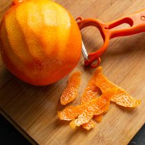 Срезаем тонкий слой оранжевой цедры овощным скребком