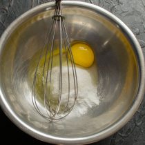 Готовим крем пломбир. Разбиваем в металлическую миску или сотейник яйцо