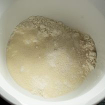 Насыпаем манную крупу, соль и сахарный песок, перемешиваем сухие ингредиенты