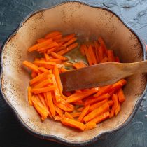 Бросаем в разогретое масло брусочки моркови. Обжариваем, помешивая, 5-7 минут