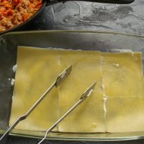 Собираем лазанью. На дно глубокой формы для запекания наливаем немного соуса бешамель, размазываем Собираем лазанью. На дно глубокой формы для запекания наливаем немного соуса бешамель, размазываем
