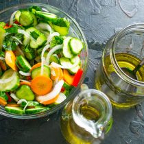 Перекладываем овощной салат в банку с оливковым маслом. Уплотняем овощи чистой сухой ложкой, вливаем сок