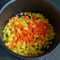 К картошке добавляем нарезанную морковь. Заливаем овощи кипящей водой, солим