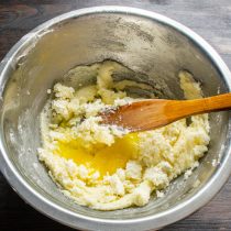 Разбиваем в тесто большое куриное яйцо, насыпаем щепотку мелкой соли. Тщательно смешиваем ингредиенты
