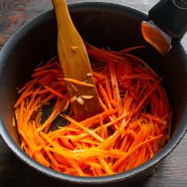 Морковь скоблим, шинкуем тонкой соломкой. Добавляем морковку в сотейник