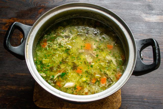 Кладем в суп мелко нарезанную курицу с солеными огурцами, перемешиваем
