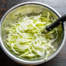 Сладкий салатный лук режем тонкими полукольцами. Добавляем к белокочанной капусте