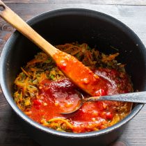 Добавляем резанные консервированные томаты вместе с томатным пюре. Нагреваем до кипения