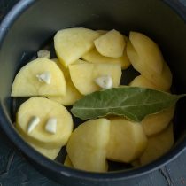 Кладём в кастрюлю картофель, добавляем чеснок и лавровый лист. Кладём в кастрюлю картофель, добавляем чеснок и лавровый лист.