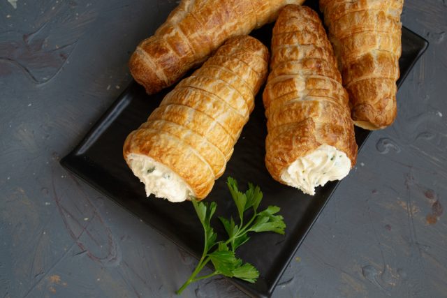 Слоёные трубочки с рикоттой сразу подаём на стол, можно испечь трубочки и приготовить начинку заранее, а перед подачей на стол наполнить начинкой и украсить.