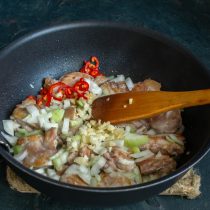 Добавляем нарезанный чили и измельченные зубчики чеснока к курице и луку. Добавляем нарезанный чили и измельченные зубчики чеснока к курице и луку.