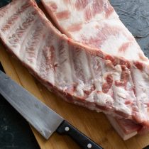 Острым ножом срезаем ребра с грудинки, прихватив солидный кусок мяса Острым ножом срезаем ребра с грудинки, прихватив солидный кусок мяса