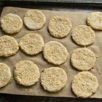 Кладём печенье липкой стороной в кунжут и выкладываем на противень, застеленный силиконовым пергаментом. Кладём печенье липкой стороной в кунжут и выкладываем на противень, застеленный силиконовым пергаментом.