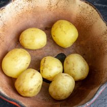 Молодой картофель скоблим, отвариваем до полуготовности