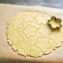 Фигурной формочкой в виде цветка с лепестками вырезаем печенья. Фигурной формочкой в виде цветка с лепестками вырезаем печенья.