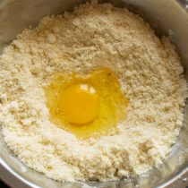 Разбиваем крупное куриное яйцо в тесто