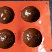 Наносим тонкий слой растопленного шоколада на стенки ячеек и убираем форму в морозильную камеру