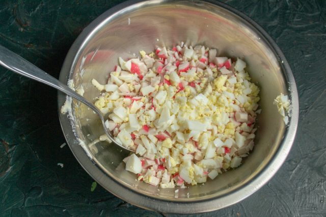 Варёные яйца также рубим мелко, добавляем к остальным ингредиентам
