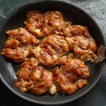 На раскаленную сковородку выкладываем маринованные куриные бёдра