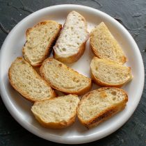 Нарезанный багет кладём в глубокую тарелку, поливаем холодным молоком или сливками