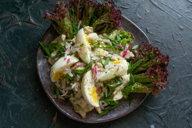 Посыпаем салат луком и редиской, перчим молотым черным перцем и сразу подаем на стол