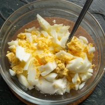 Вареные яйца охлаждаем, чистим, режем кубиками, добавляем к сыру