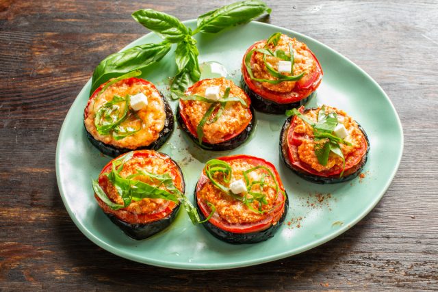 Запеченные баклажаны аккуратно снимаем с противня, посыпаем нарезанным базиликом