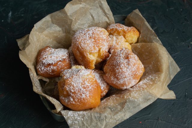 Готовые пончики из заварного теста посыпаем сахарной пудрой и подаём горячими
