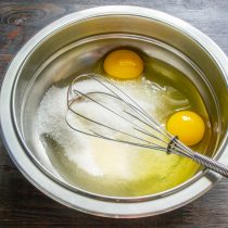 Насыпаем в миску сахарный песок, разбиваем куриные яйца