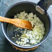 Головку репчатого лука и зубчик чеснока режем мелко, бросаем в сотейник Головку репчатого лука и зубчик чеснока режем мелко, бросаем в сотейник