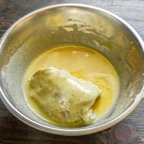 Когда масло разогреется, обмакиваем куриные бедра в кляр