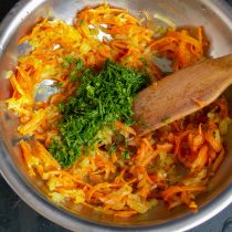 Добавляем к обжаренным овощам примерно две столовые ложки рубленной зелени. Добавляем к обжаренным овощам примерно две столовые ложки рубленной зелени.