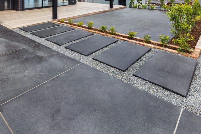 Темная бетонная плитка в мощении смотрится элегантно и стильно.