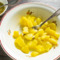 Отваренный в мундире картофель нарезаем крупными кубиками, выкладываем в миску. Отваренный в мундире картофель нарезаем крупными кубиками, выкладываем в миску.