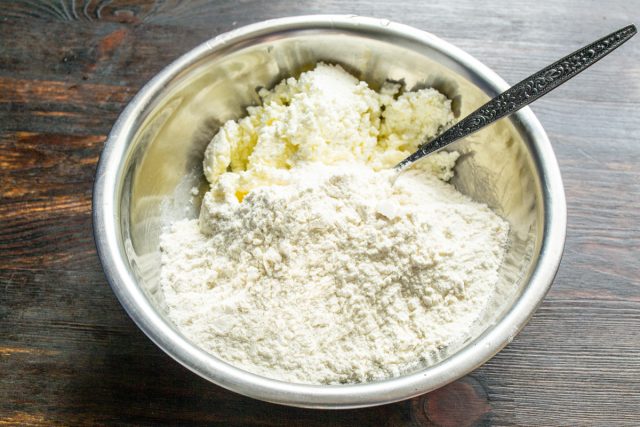 Высыпаем сухие ингредиенты в миску с маслом и творогом.