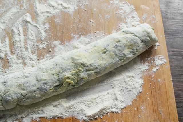 Выкладываем на муку тесто, скатываем из него колбаску, толщиной примерно 4 сантиметра.