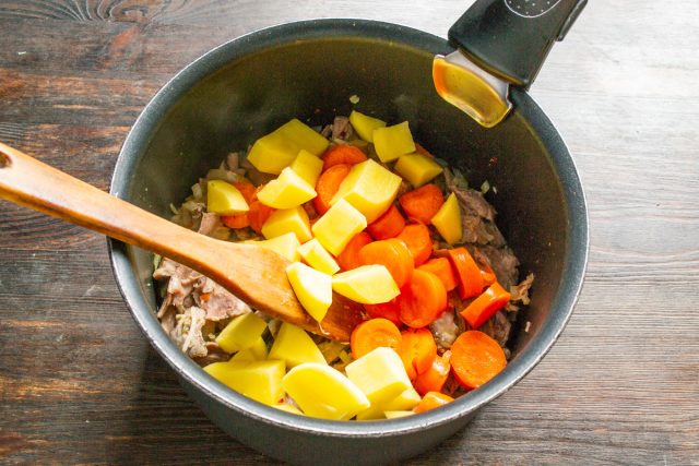 Отправляем в кастрюлю нарезанный картофель следом за морковью. Отправляем в кастрюлю нарезанный картофель следом за морковью.