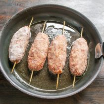 Выкладываем колбаски на шпажках на разогретую сковороду. Выкладываем колбаски на шпажках на разогретую сковороду.