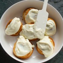 Обильно смазываем тёплые лимонные булочки сливочной глазурью.