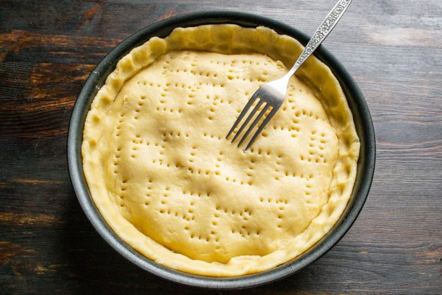 Вилкой протыкаем тесто в нескольких местах, чтобы во время выпечки пар из начинки мог прорываться наружу.