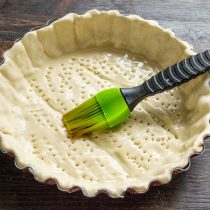 Смазываем тесто с помощью силиконовой кисти или флейца – дно, края и кант.