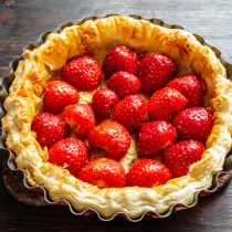 Выкладываем половинки клубники на испеченную основу из слоеного теста.