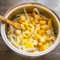 Отправляем нарезанный картофель в кастрюлю следом за капустой.