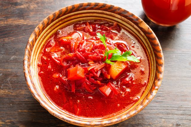 Подаем борщ горячим. Можно приправить толченым чесноком, молотым черным перцем и посыпать зеленым луком.