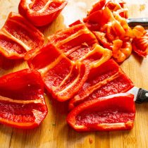 Отрезаем верхушки половинкой перца. Острым ножом срезаем перегородки.