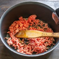 Следом бросаем нарезанную тонкими полукольцами луковицу и измельченный зубчик чеснока.