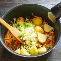 Кладем в кастрюлю капусту и картофель.