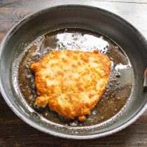 Переворачиваем шницель и поджариваем с другой стороны до золотистой корочки.